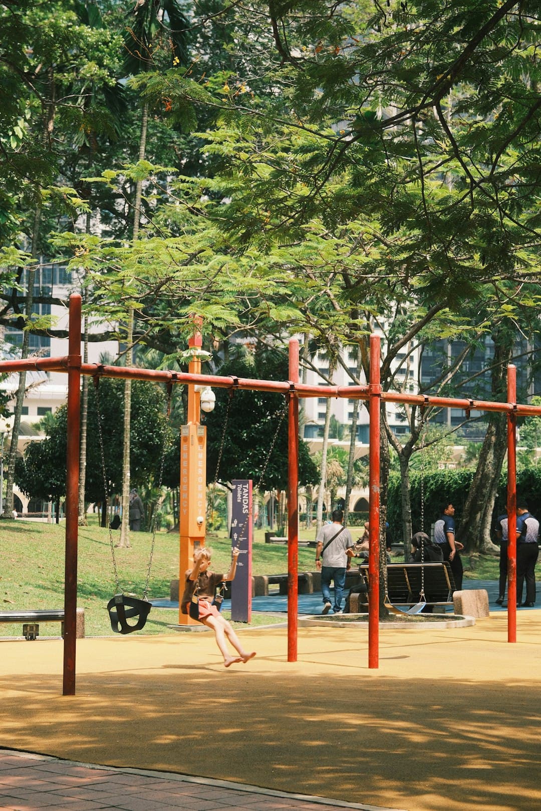 Dziecko na placu zabaw w parku huśta się.