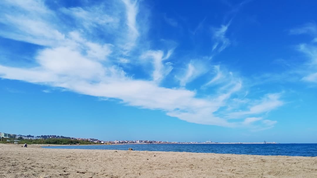 Spokojna plaża w Castelldefels pod czystym niebem