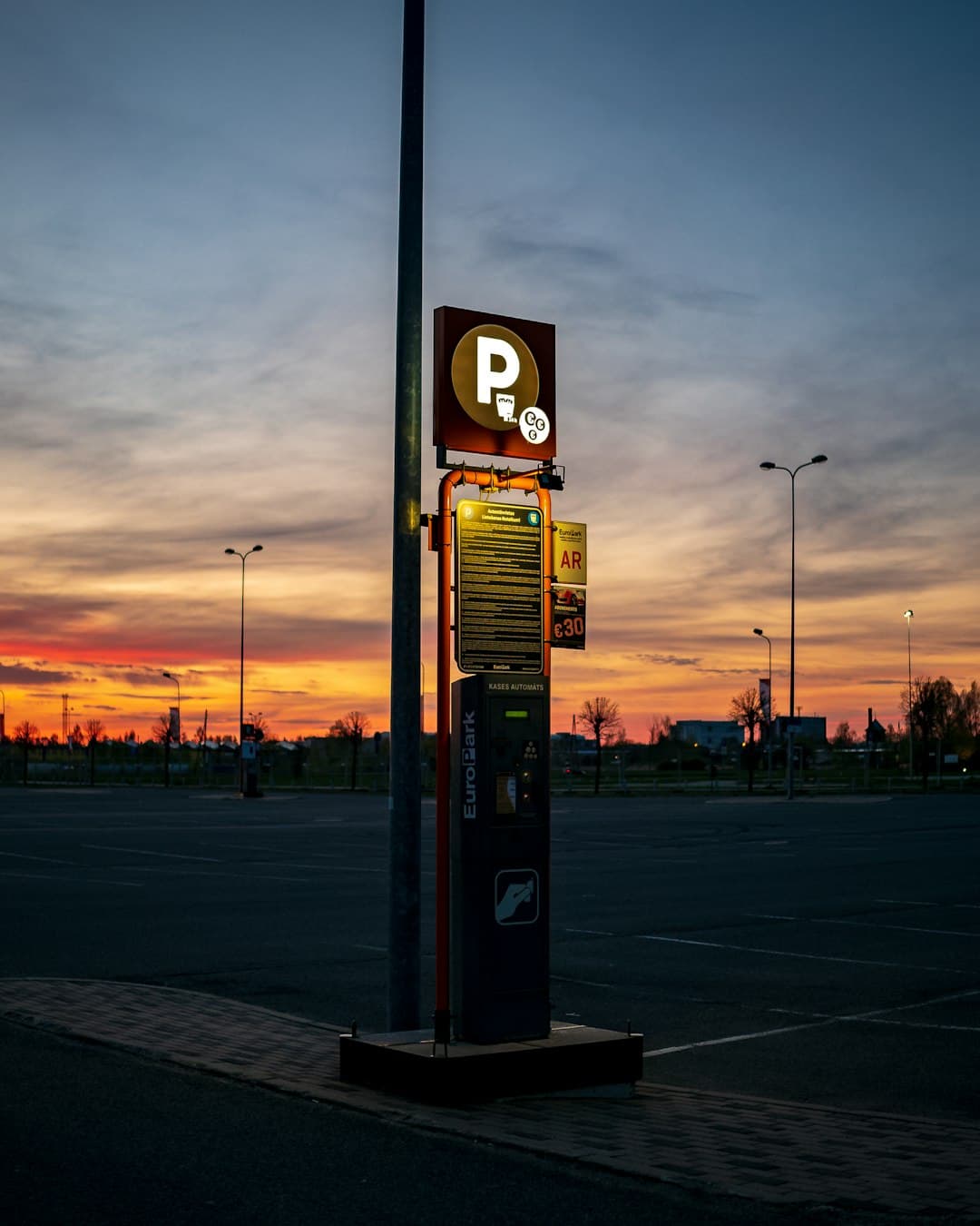 Automat parkingowy na tle zachodu słońca.