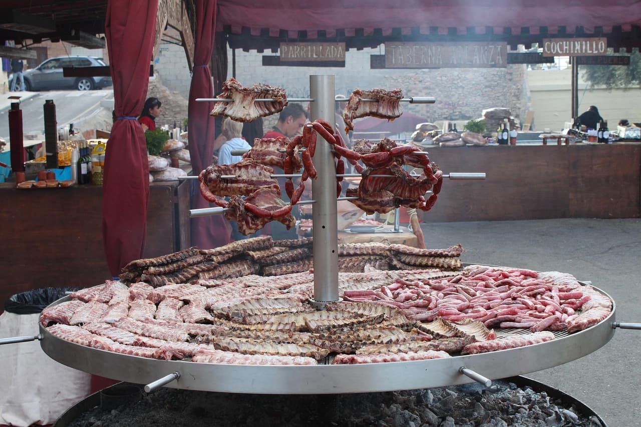Ogromny grill z żeberkami, kiełbasami i mięsem na targu ulicznym.
