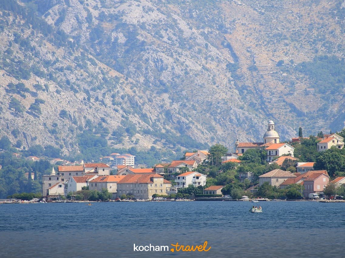 Nadmorskie miasteczko, domy, kościół, góry, zatoka, słoneczny dzień.