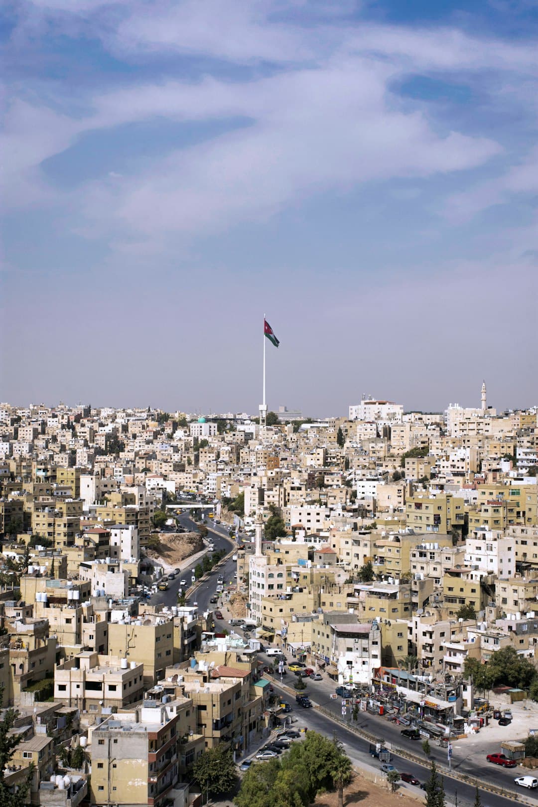 Panoramiczny widok na Amman z flagą Jordanii.