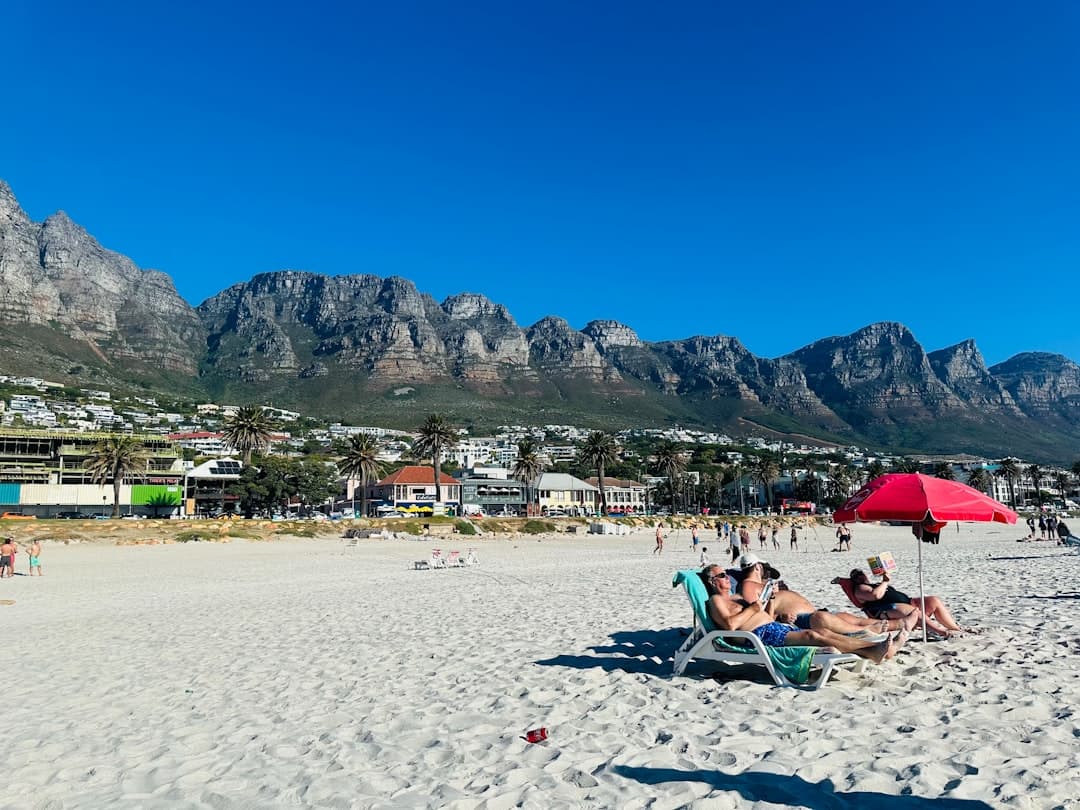 Turyści relaksujący się na piaszczystej plaży z górami