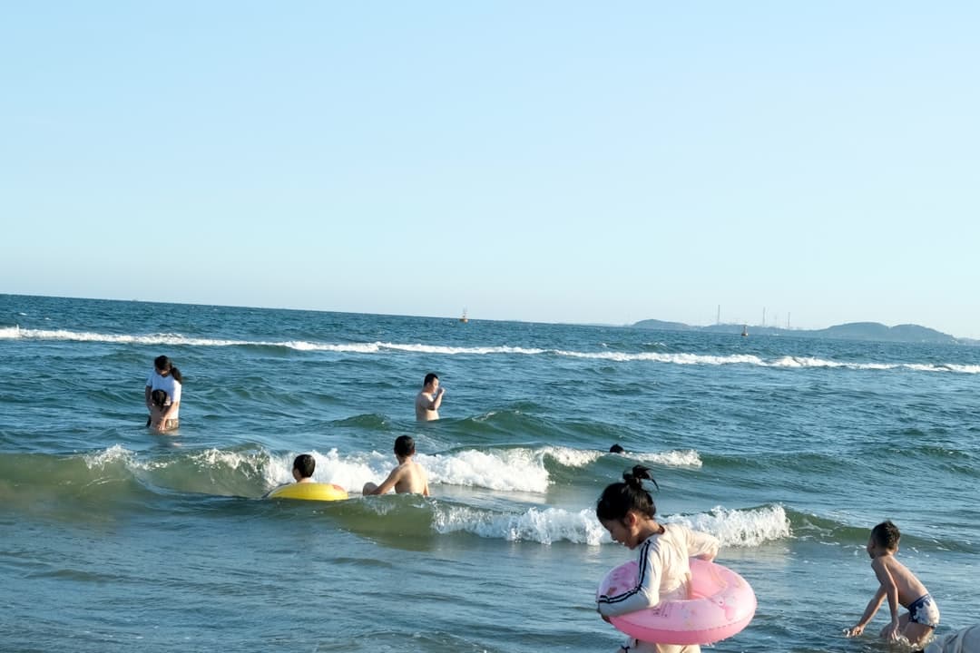 Ludzie bawiący się w morzu przy plaży.