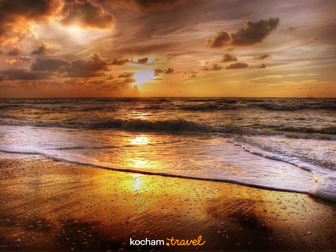 Zachód słońca nad oceanem, złote światło, fale na piaszczystej plaży