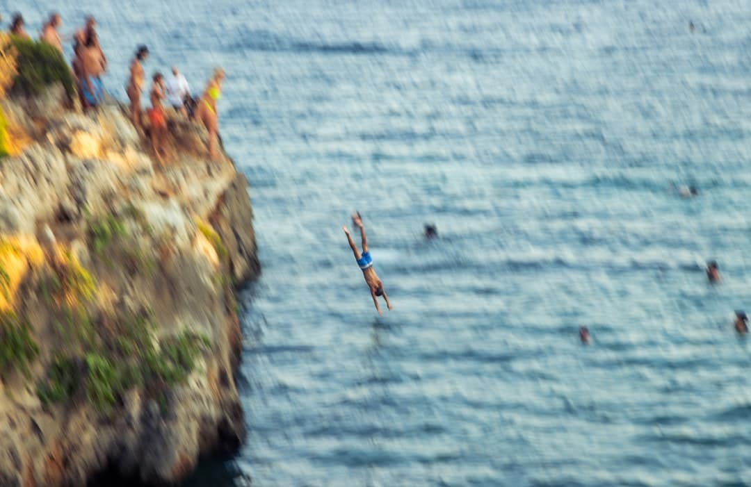 Osoby skaczące w dół w krystalicznie czystym morzu