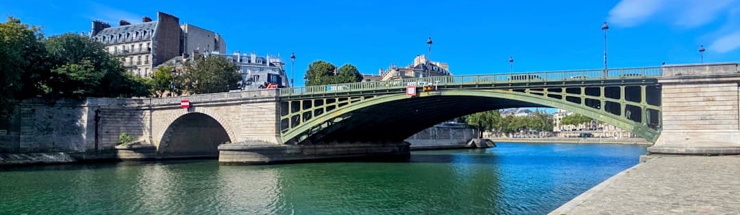 Zabytkowy most nad spokojną rzeką w słoneczny dzień