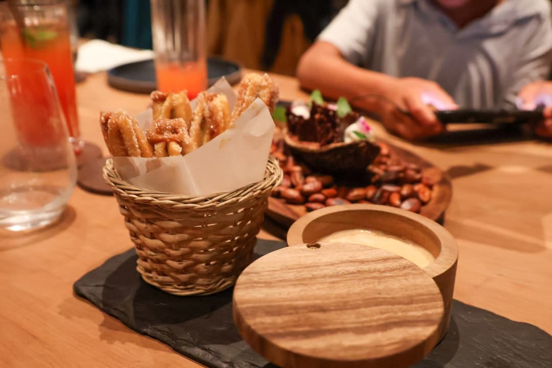 Churros na stole z sosem w drewnianej misce