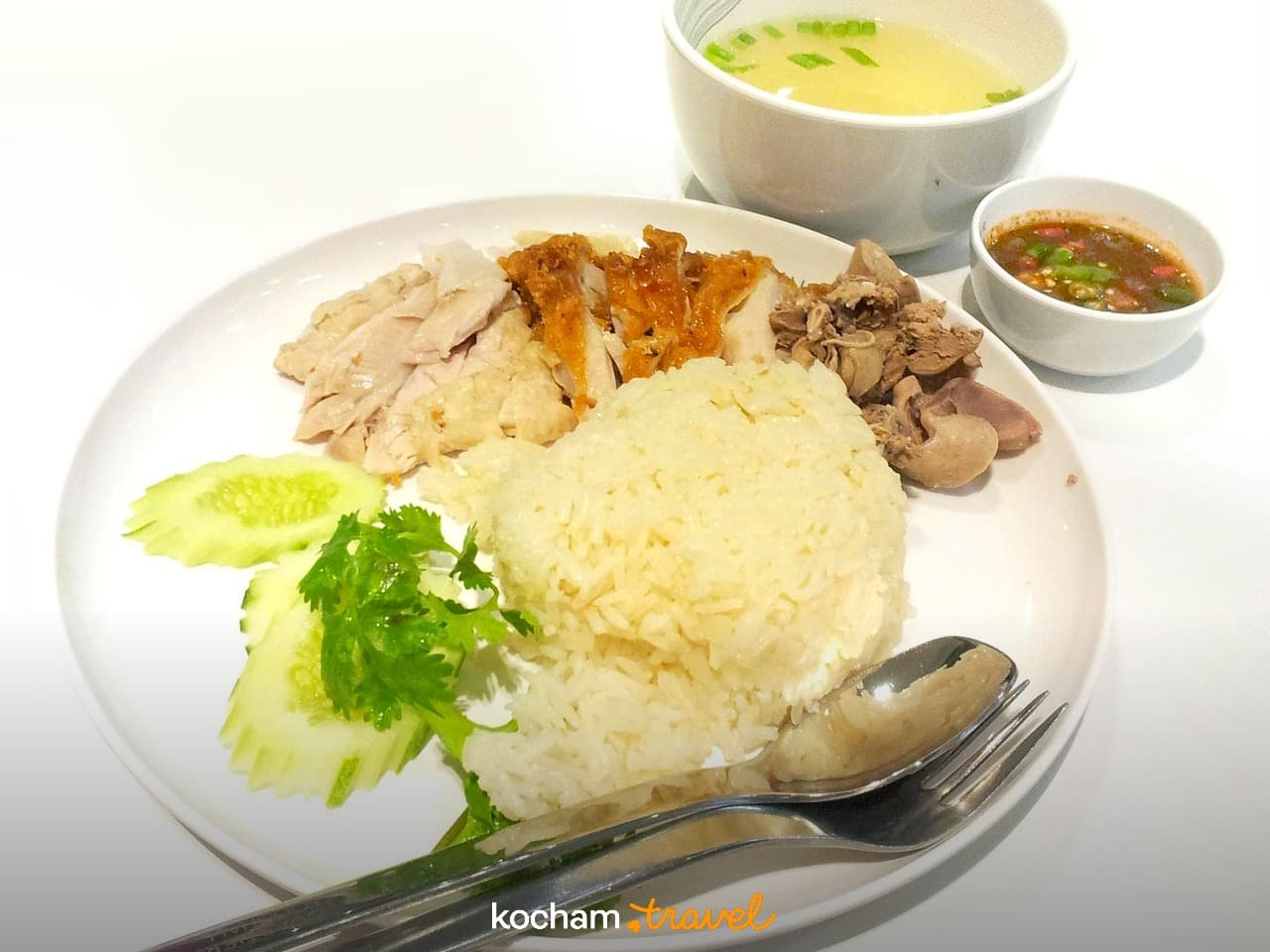 Hainanese kurczak z ryżem, zupą, sosem i świeżym ogórkiem.