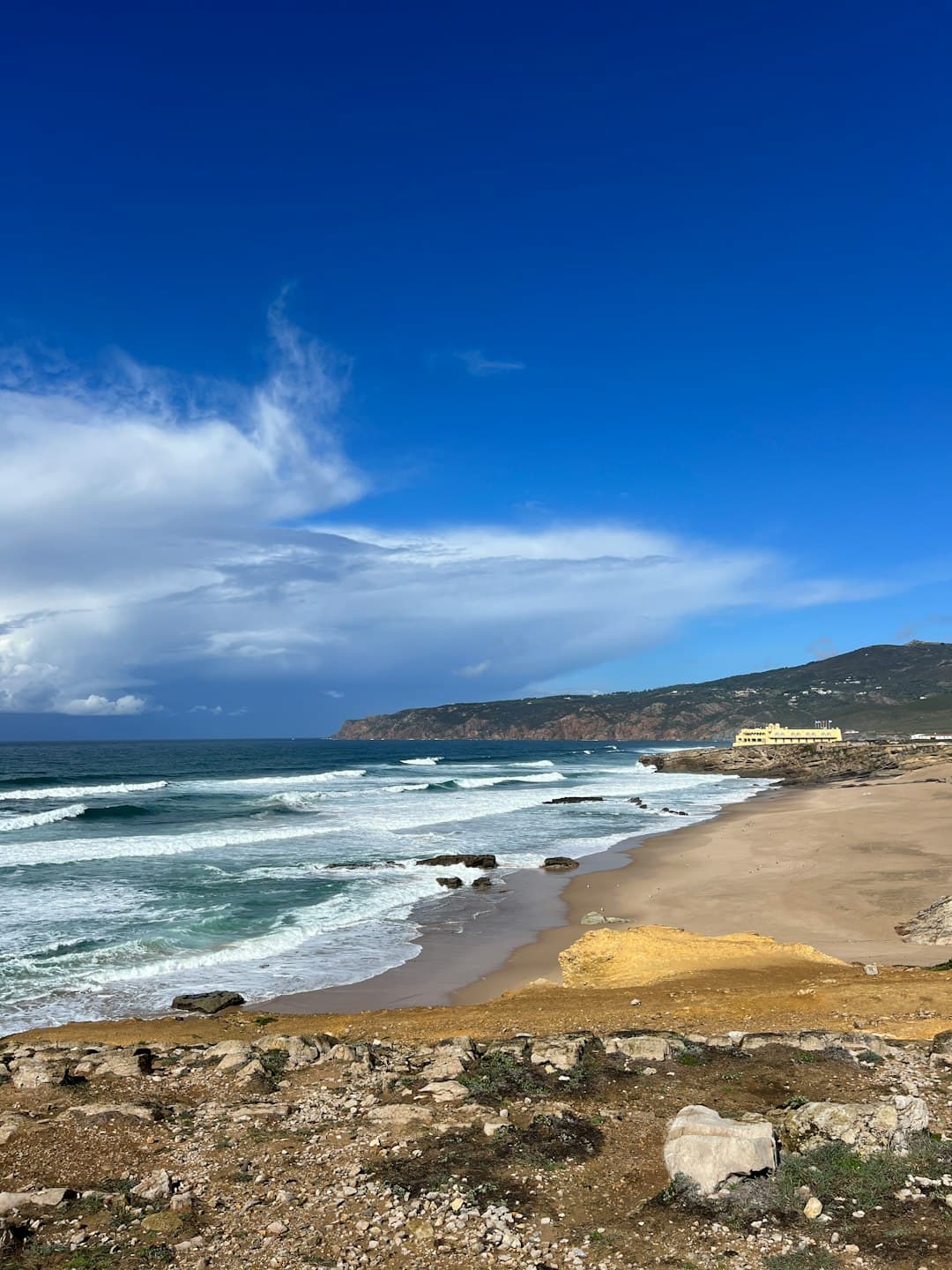 Czysta plaża w Cascais z widokiem na skały