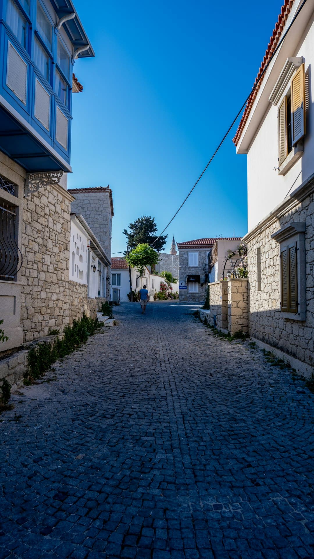 Urokliwe uliczki Alaçatı z białymi domami i kolorowymi kwiatami