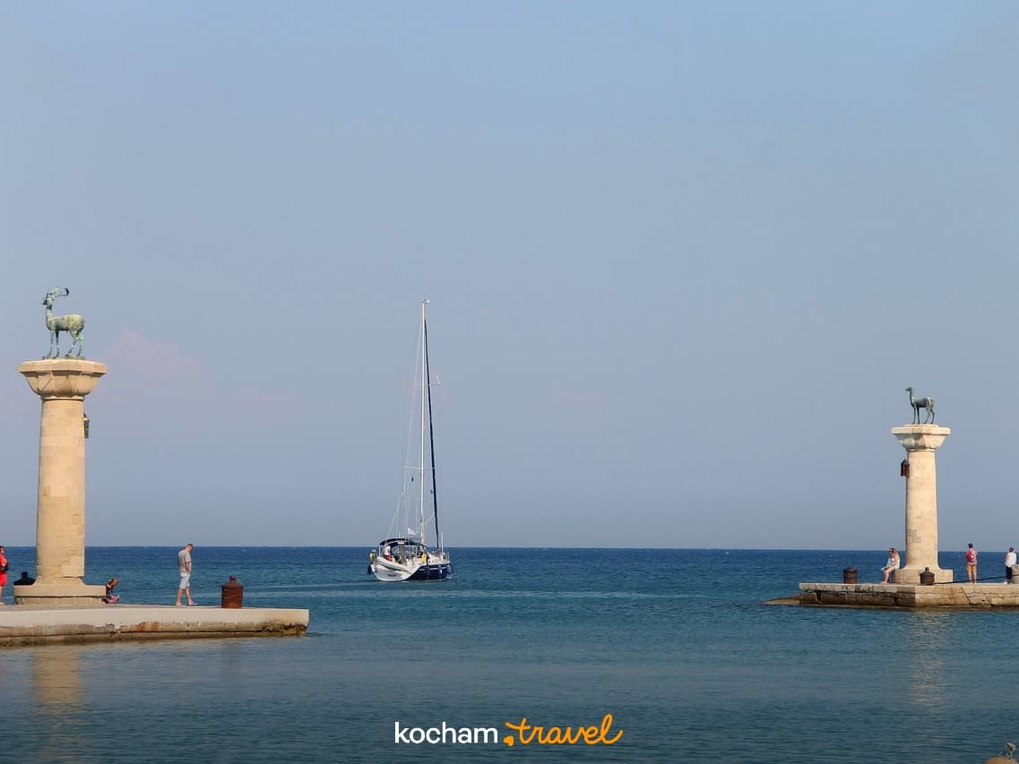 Port Mandraki Rodos posągi jeleni żaglówka turkusowe morze Grecja