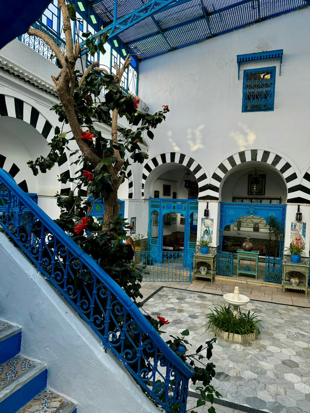 Tradycyjny dziedziniec tunezyjski z niebieskimi i białymi elementami.