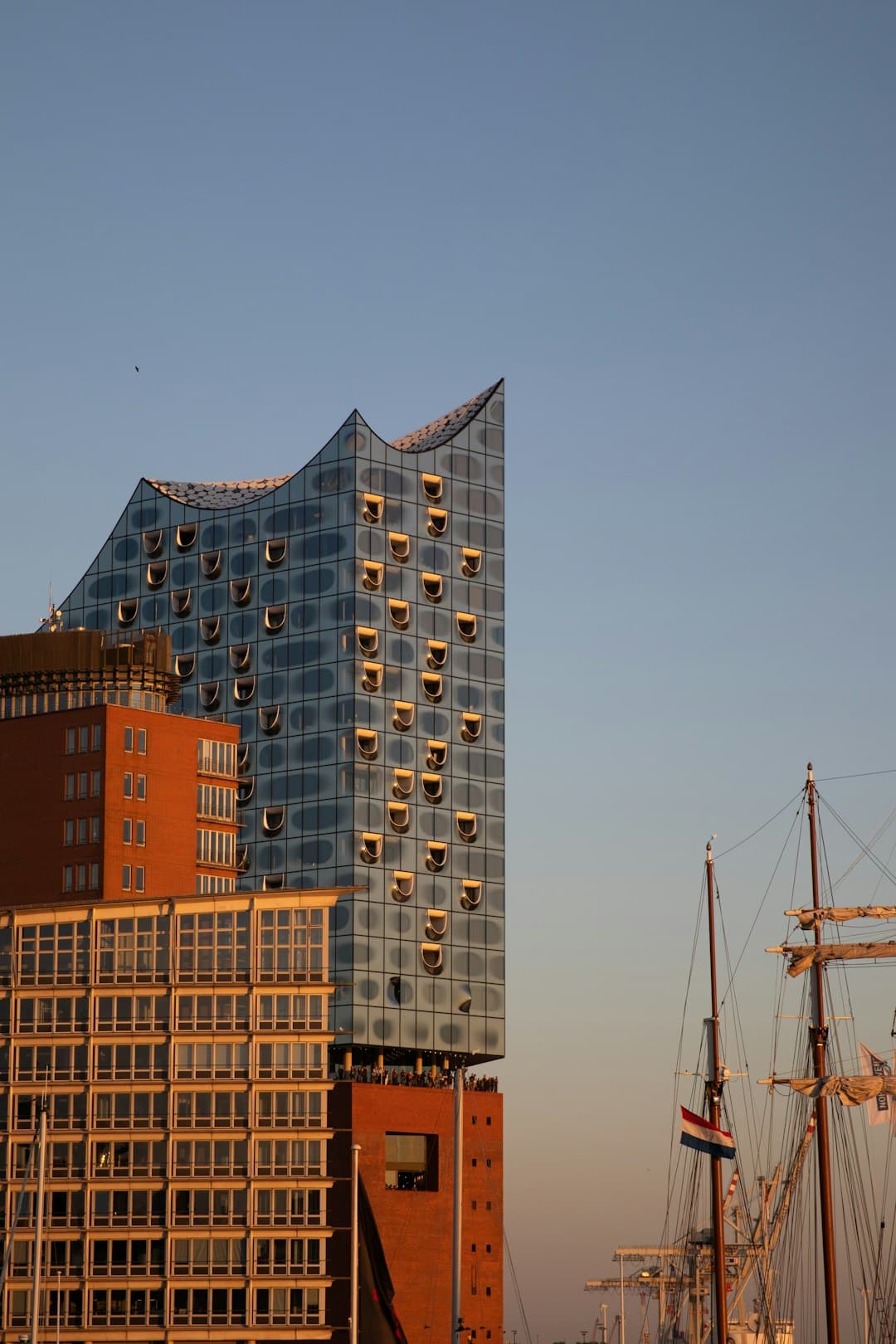 Nowoczesny budynek z półprzezroczystymi oknami i żaglówką.