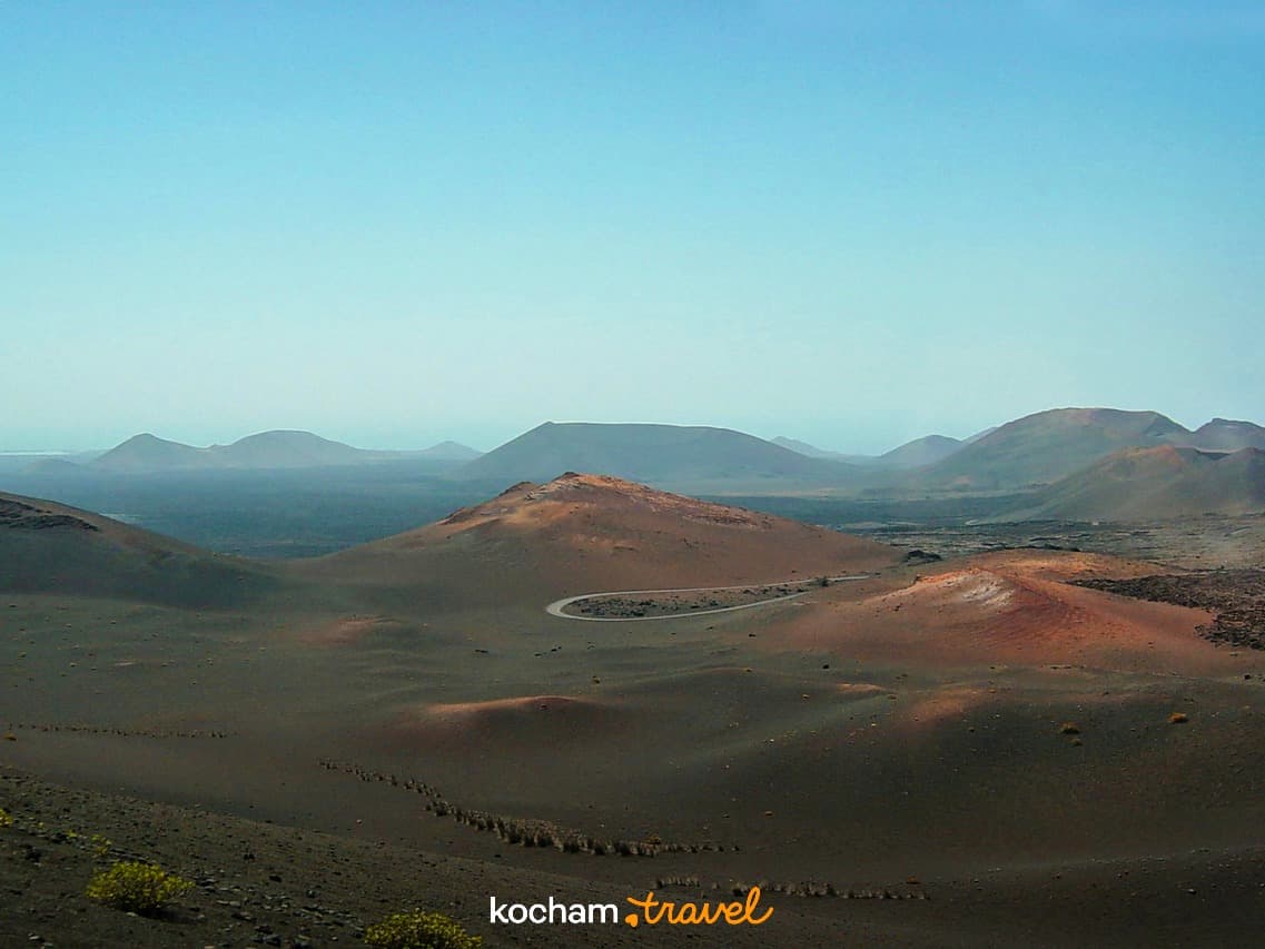 Panoramiczny krajobraz wulkaniczny, kręta droga, wzgórza, suchy teren, Lanzarote.