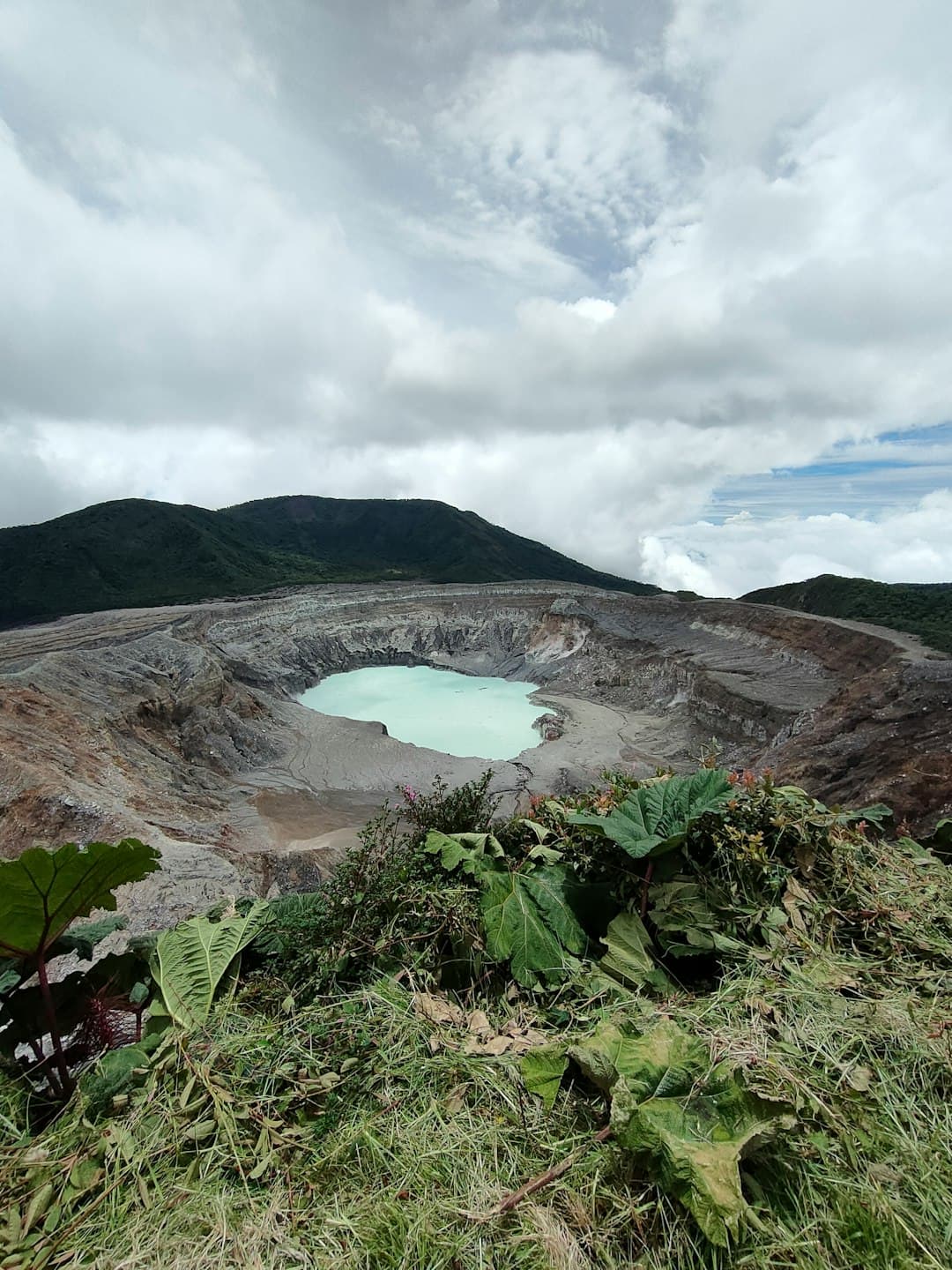 Wulkaniczny krater jezioro turkusowe chmury roślinność