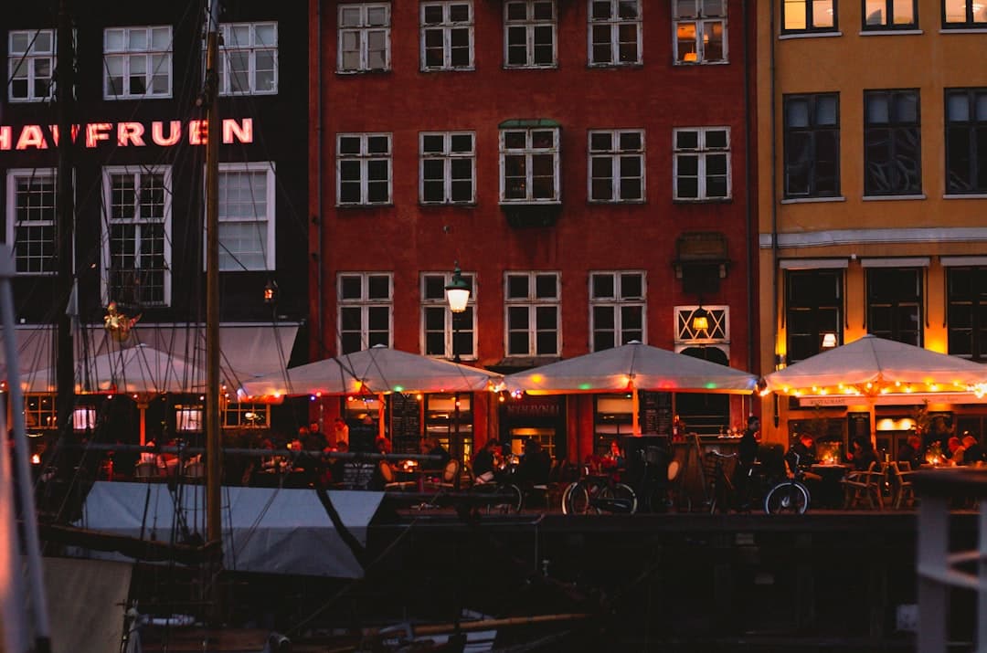 Przyjaciele wznoszący toast piwem w barze w Kopenhadze