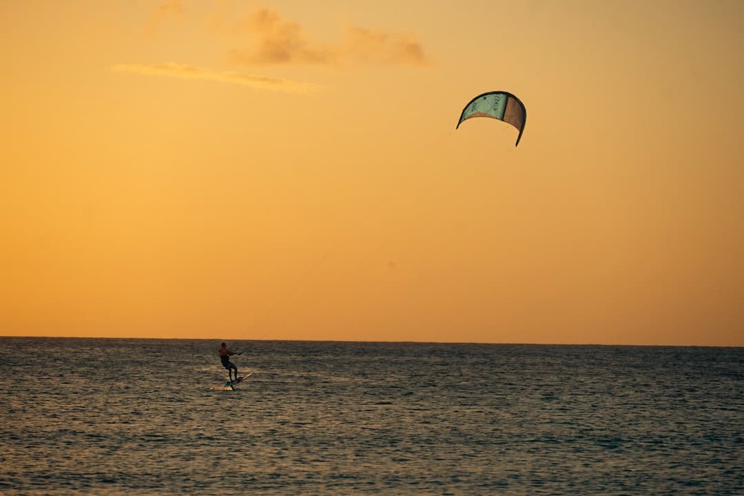 Kitesurfing o zachodzie słońca nad morzem.