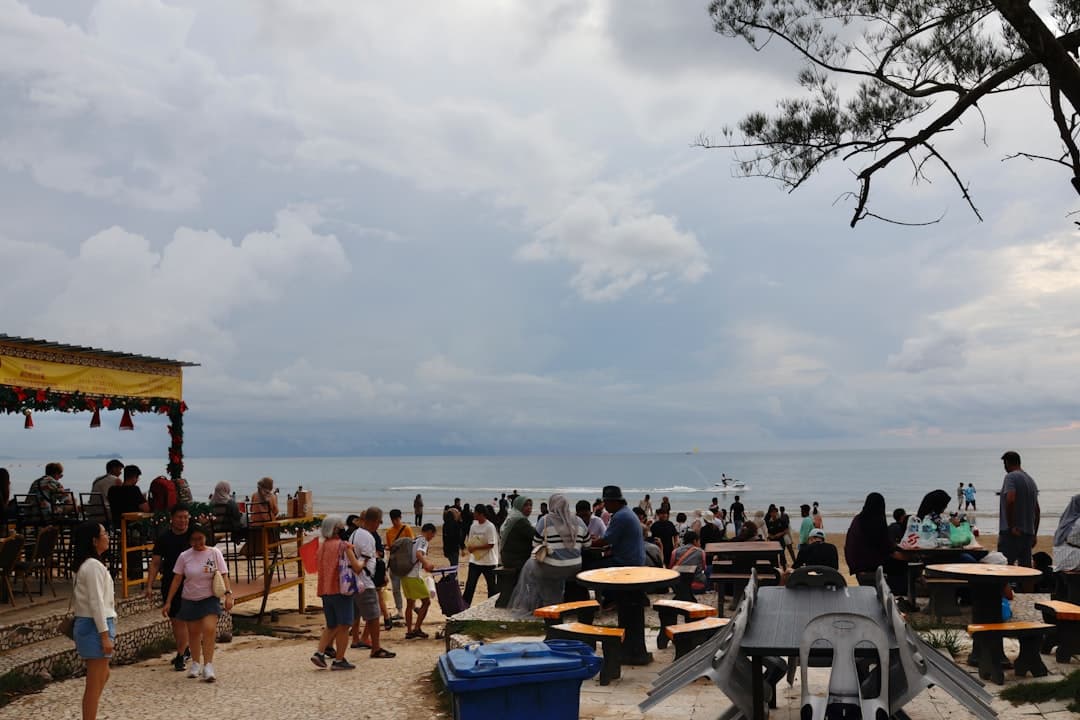 Ludzie na plaży z widokiem na morze i niebo.