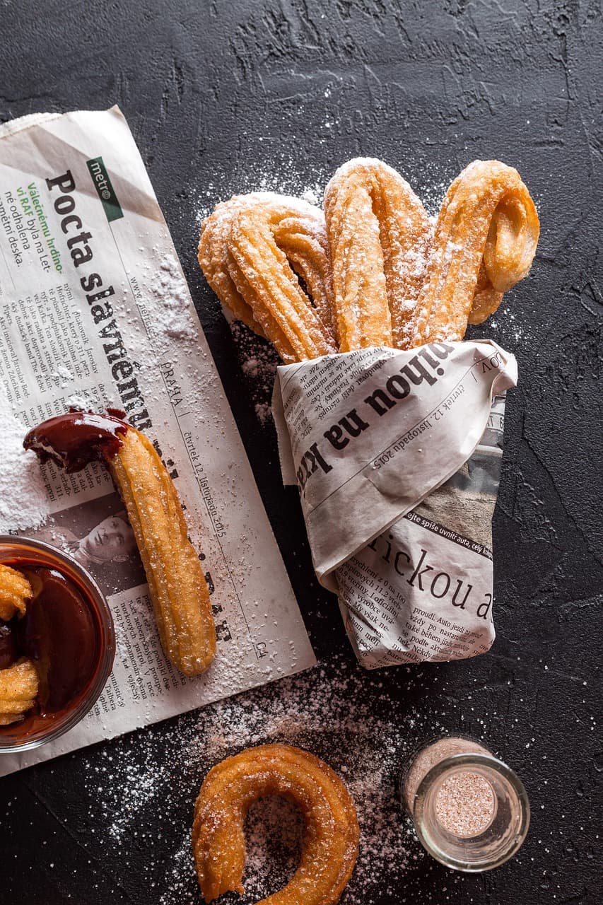 Churros obtoczone w cukrze podane na talerzu